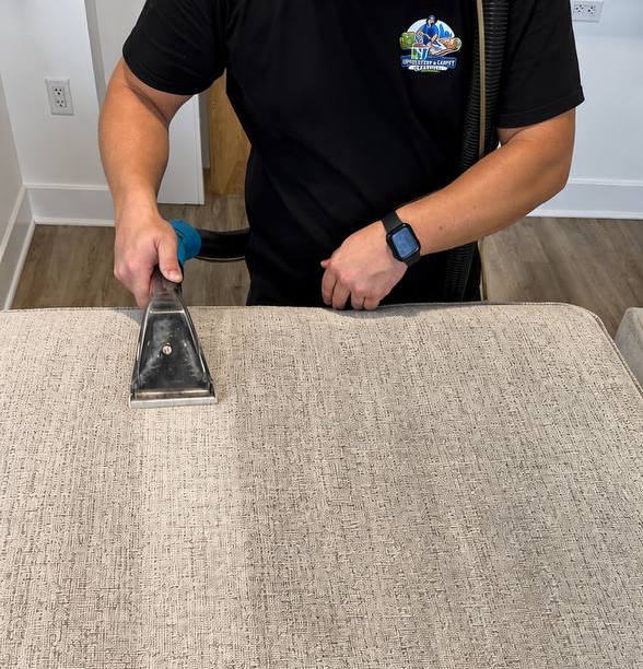 Professional cleaner treating a sofa stain